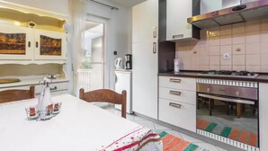 Una cocina moderna con armarios blancos, estufa a gas y cafetera.