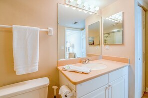 Une salle de bain avec un lavabo blanc, un miroir et un porte-serviettes.