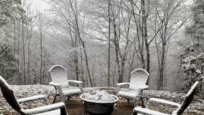 A patio area with four chairs and a table, surrounded by snow-covered trees. - Sleeps 6・Cozy Cabin・Spacious Outdoor・View・Firepit (Sevierville)