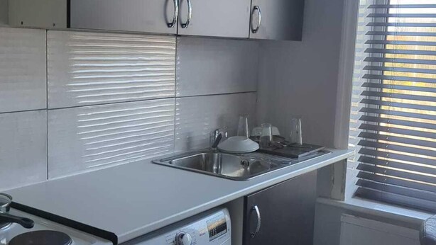 A kitchen with a built-in stove, a sink, and cabinets.
