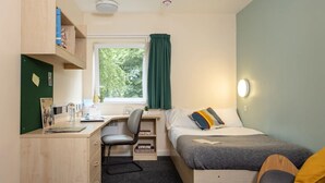 A compact room with a desk, chair, bed, and a window with curtains. - Bonington Student Village - Campus Accommodation (Sutton Bonington)