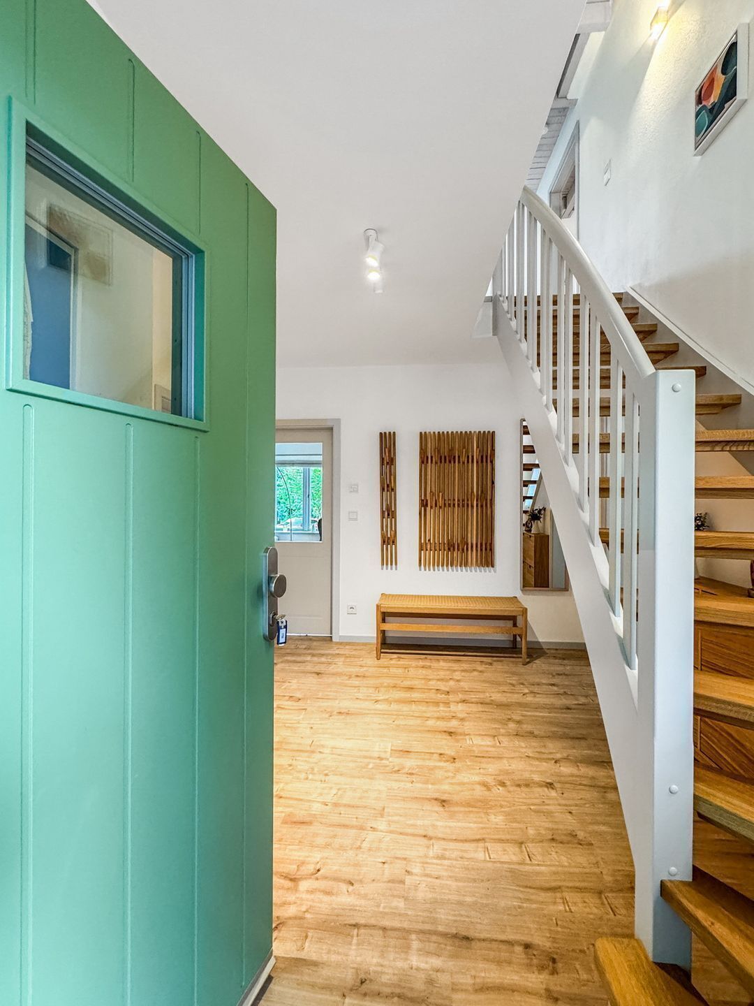 A staircase with wooden steps and white railings leading to an upper floor.