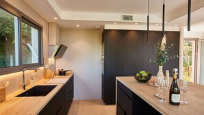 Een moderne keuken met een groot schiereiland, inbouwapparatuur en uitzicht op de omgeving.