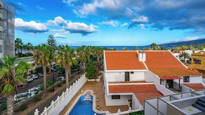 A coastal hotel with a swimming pool, palm trees, and a view of the ocean. - BAL Apartments - Adults Only (Arona)