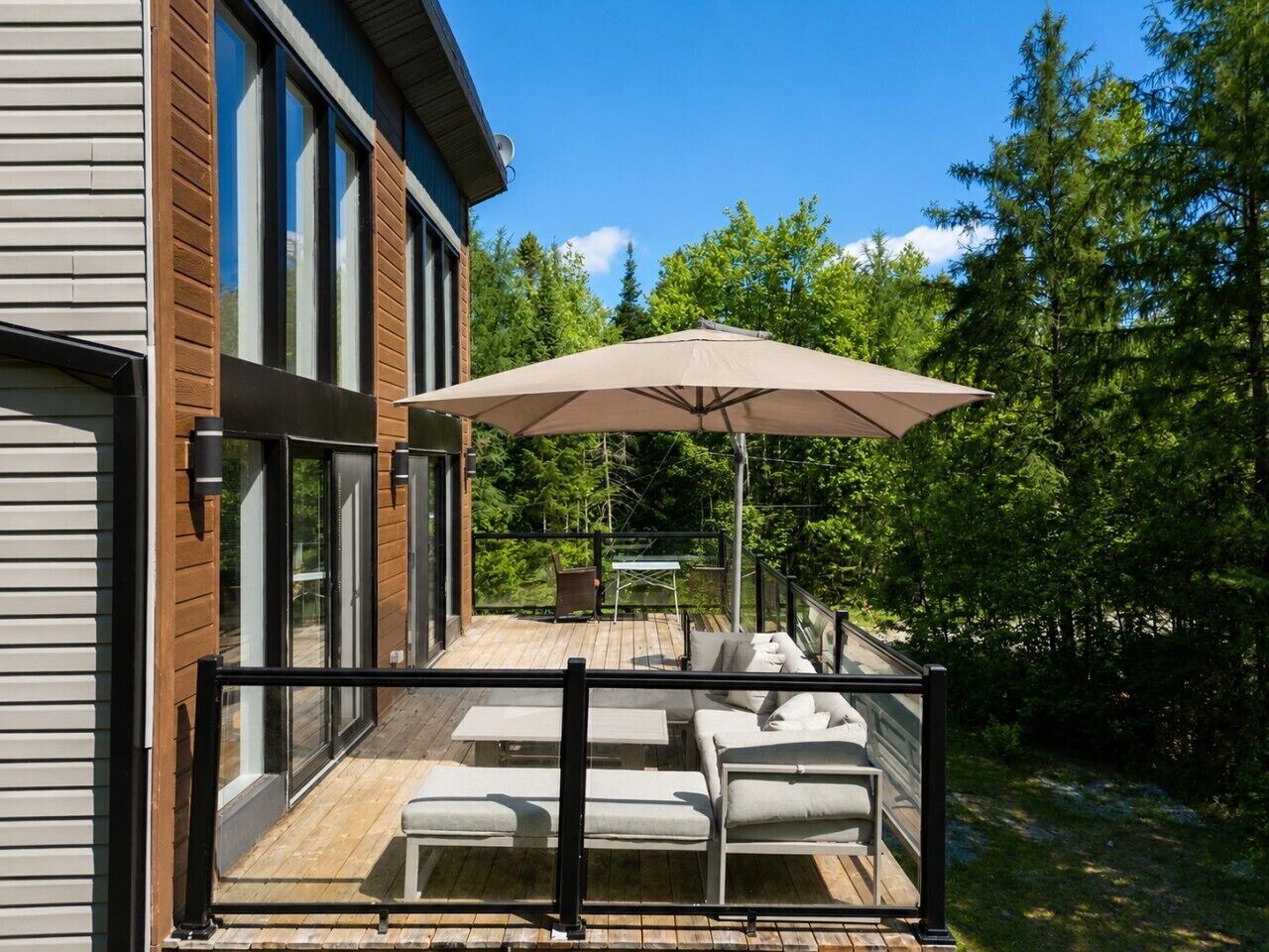 A deck with outdoor furniture and a large umbrella.