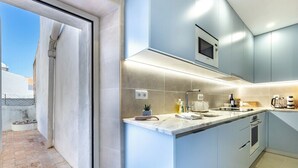A modern kitchen with a large island, built-in appliances, and a view of the outside. - Casa Matias - Stylish 4BR Apartment • Lagos Old Town (Lagos)