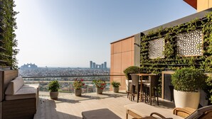 A rooftop terrace with outdoor seating, potted plants, and a view of the cityscape. - 4BR Maid Palm Penthouse w Atlantis Views Beach Access (Dubai)