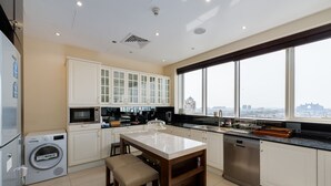 A modern kitchen with a large island, built-in appliances, and a view of the city. - 4BR Maid Palm Penthouse w Atlantis Views Beach Access (Dubai)