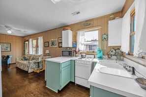Enjoy cooking in this well-equipped kitchen with a central island, microwave, stove, and sink.