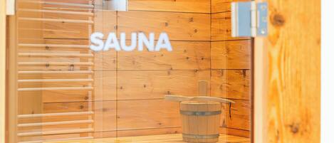 Een sauna met houten wanden en een bordje met de tekst 'SAUNA'.
