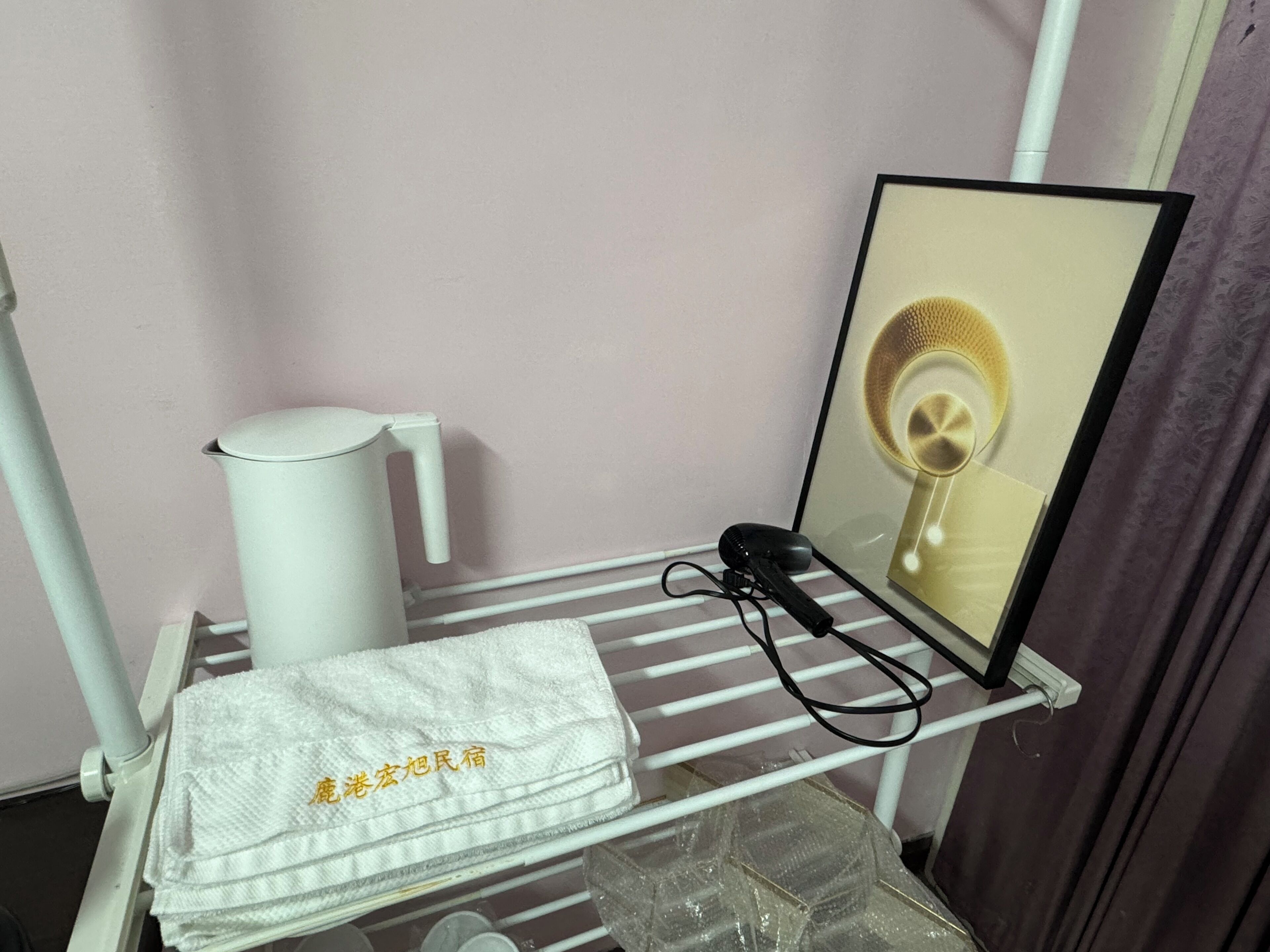 A bathroom with a towel rack holding a white towel and a hairdryer.