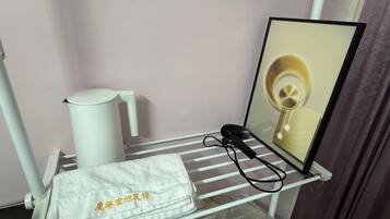 A bathroom with a towel rack holding a white towel and a hairdryer.