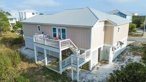 A two-story house with a balcony, a covered porch, and a small deck.