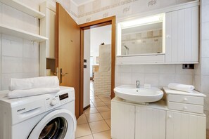 A modern bathroom with a washing machine, a sink, and a mirror. - Casa Del Profeta - Mountain View Balcony (Arco)
