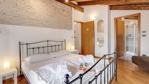 A bedroom with a bed, bedside table, and a brick wall.