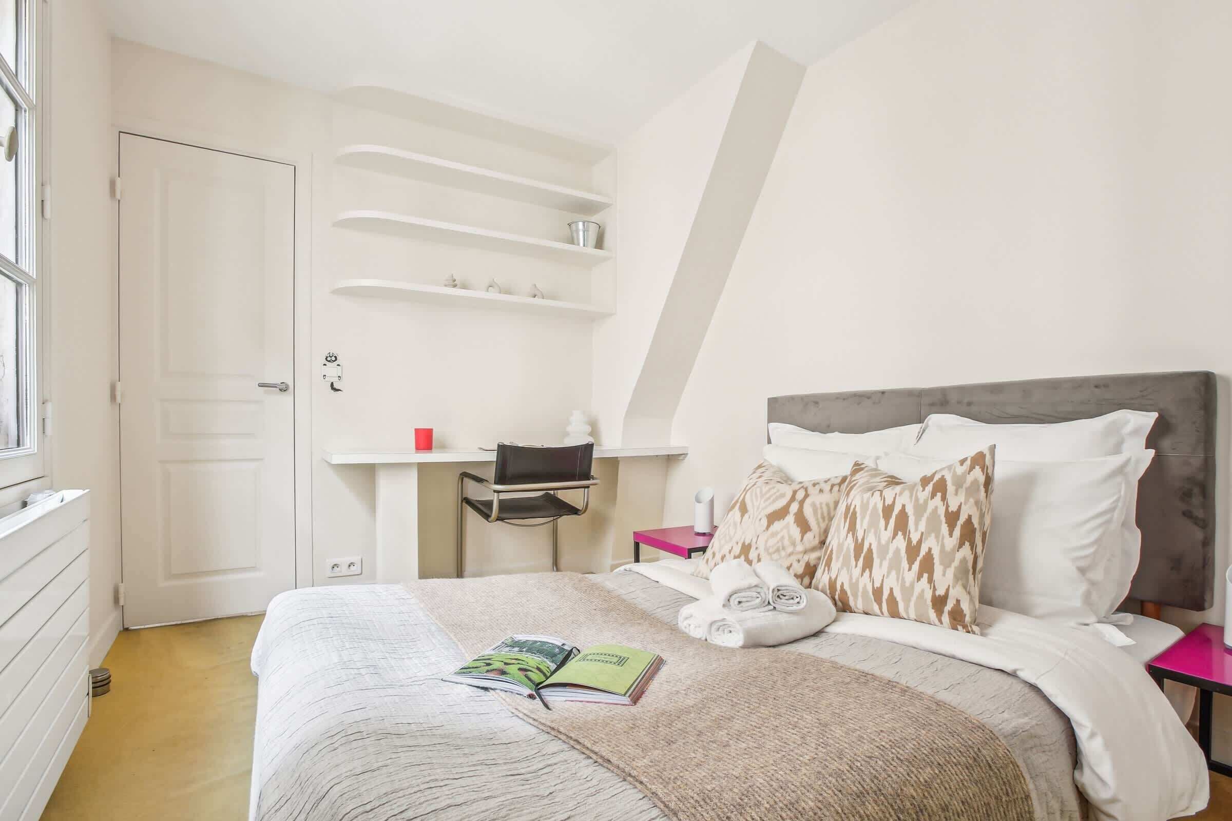 Una camera da letto con un letto, una scrivania e una sedia.