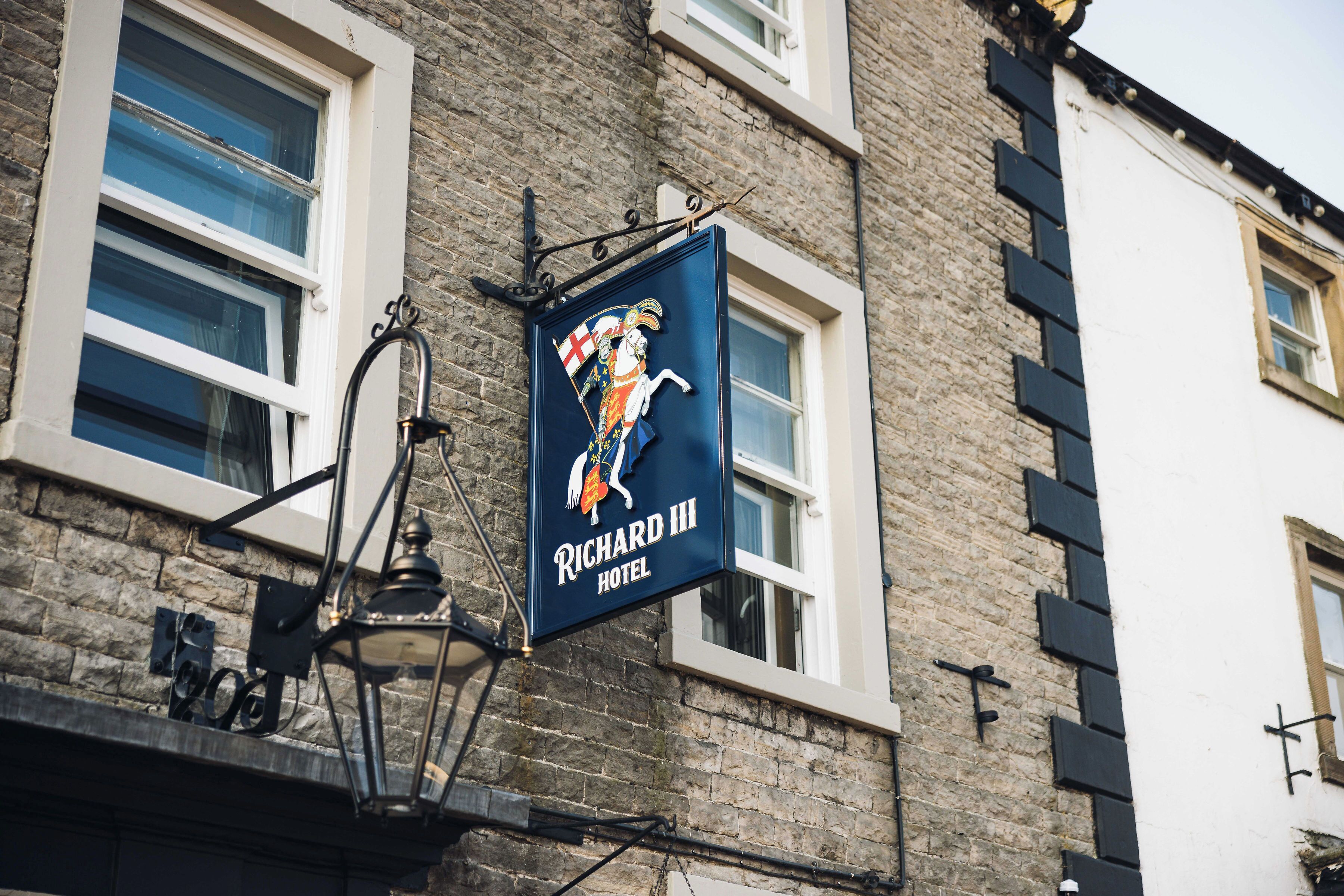 Letrero del Hotel Richard III con un escudo de armas y la figura de un caballero.