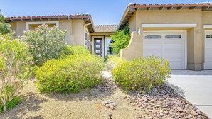 A residential property with a beige stucco exterior, a tiled roof, and a front yard with a gravel pathway and various shrubs. - Private Pool & Mtn Views: Luxe Palm Springs Home! (Palm Springs)