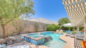 A swimming pool with a tiled deck, lounge chairs, and a pergola. - Private Pool & Mtn Views: Luxe Palm Springs Home! (Palm Springs)