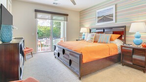 A bedroom with a bed, a dresser, a nightstand, a ceiling fan, and a view of the outdoors through a sliding door. - Private Pool & Mtn Views: Luxe Palm Springs Home! (Palm Springs)