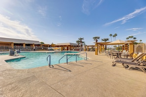 A pool area with lounge chairs, a pool, and a building in the background. - Pool Access + Private Backyard: Sunny Mesa Home (Mesa)