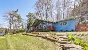 A blue house with a porch and a stone pathway leading to it.