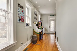 A hallway with wooden flooring, a 3D printer, and a door labeled 'LOUST'.