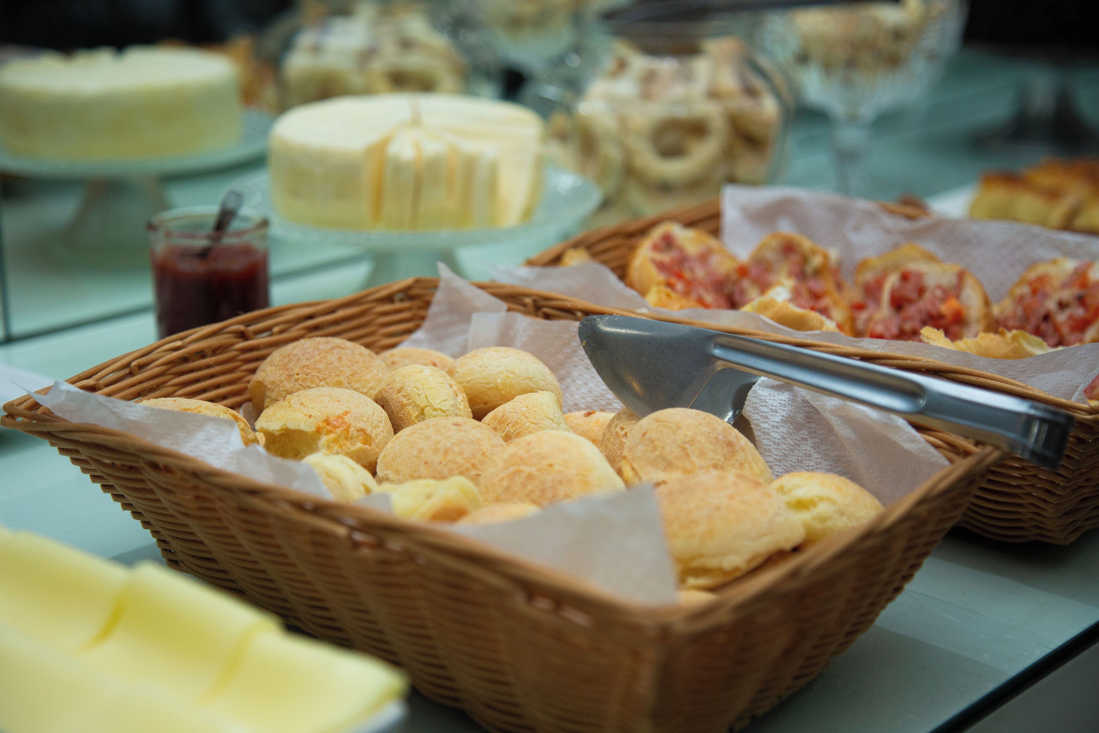 Un bufé con diferentes opciones de comida, incluyendo pan, bollería y postres.