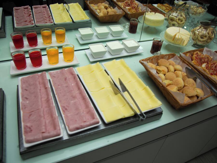 A buffet with various food items including meats, cheeses, and pastries.