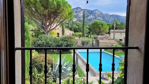 A balcony with a pool, surrounded by greenery and a mountain view. - La Villa de Robion in Robion (Robion)