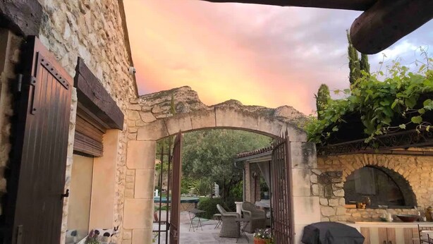 An outdoor patio area with stone walls, a wooden archway, and outdoor furniture. - La Villa de Robion in Robion (Robion)