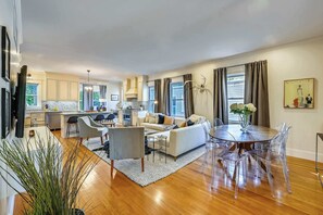 A modern living room with a sofa, coffee table, and dining table with chairs.