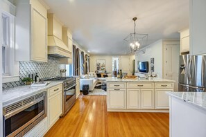 A modern kitchen with white cabinetry, stainless steel appliances, and a central island.