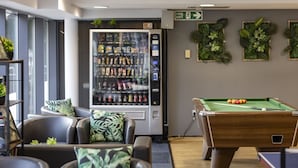 A pool table, a vending machine, and a seating area with a view of the outdoors. - Belgrave View - Campus Accommodation (Birmingham)