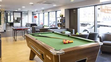 A pool table with balls, a billiards cue, and a green felt surface.