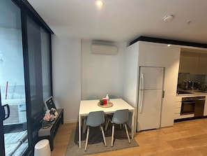 Eine moderne Küche mit Kühlschrank, Backofen und einem Essbereich mit Tisch und Stühlen.