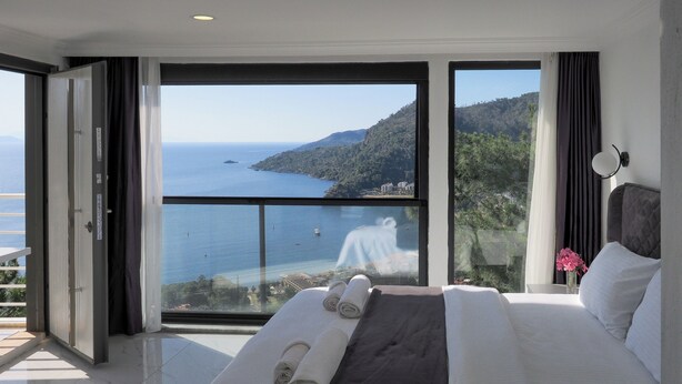 A bedroom with a large bed, a view of the sea, and a balcony. - Oliva Mare (Turunc)