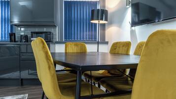 Una cocina moderna con comedor, una mesa oscura y sillas amarillas.