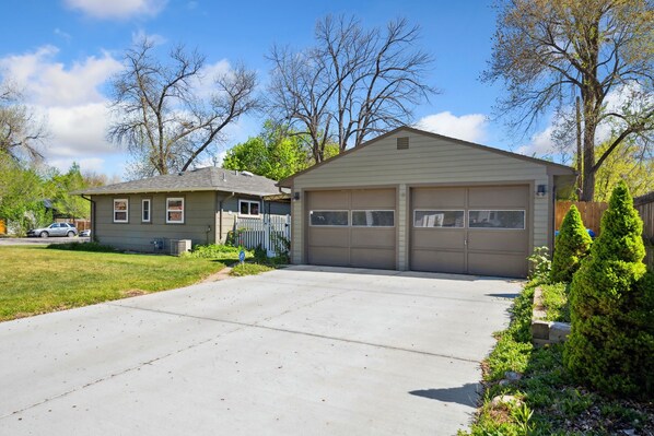 A single-story house with a garage, a small attached shed, and a well-maintained lawn.