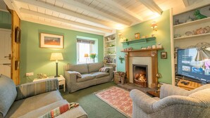 A cozy living room with a fireplace, a television, and a bookshelf.