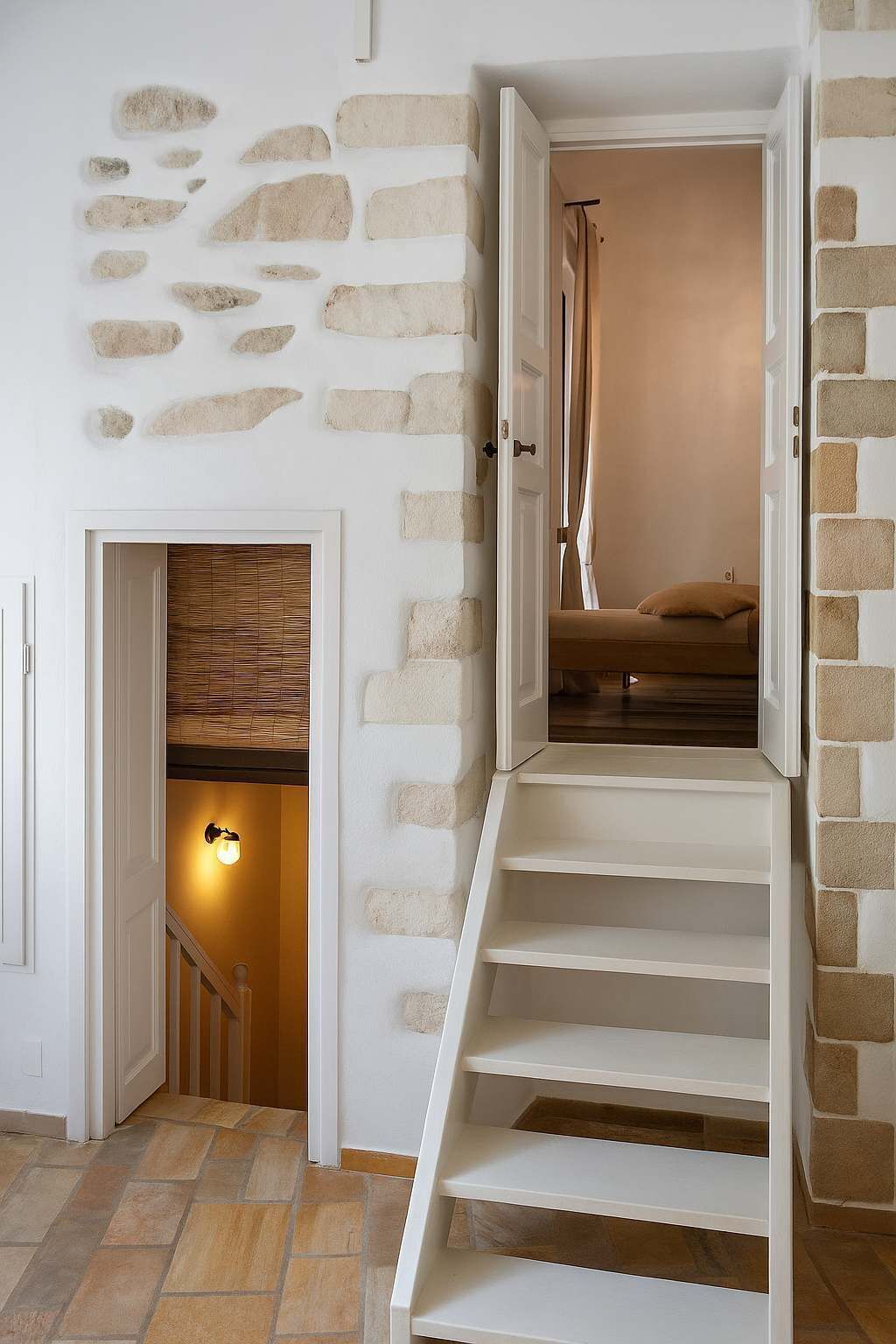 A staircase leading to a bedroom with a bed and a shower.