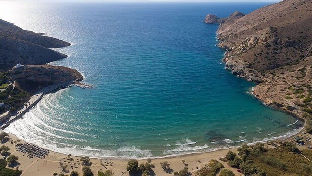 Une zone côtière comprenant une plage, des falaises rocheuses et une vue dégagée sur la mer.