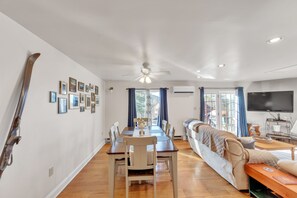 Relax in this spacious living area with a dining table for four, comfortable seating, and a large television.