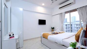Une chambre d’hôtel avec un lit, un bureau, une télévision et une fenêtre donnant sur la ville.