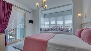 Ein Schlafzimmer mit einem großen Bett, einem Fenster mit Blick und einem Kronleuchter.