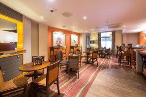 A hotel room with a dining area, a bar, and a large window with curtains. - Premier Inn Liverpool City Centre - Moorfields (Liverpool)
