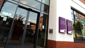 L’entrée d’un hôtel Premier Inn, avec une grande façade en verre, une façade extérieure en briques et une enseigne au-dessus des portes.