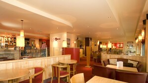 A restaurant with wooden furniture, a bar area, and a counter with a menu. - Premier Inn Belfast City Centre Alfred St (Belfast)