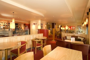 A restaurant with wooden furniture, a bar area, and a counter with a menu. - Premier Inn Belfast City Centre Alfred St (Belfast)