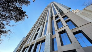 Un edificio alto y moderno con una entrada destacada y ventanas amplias.
